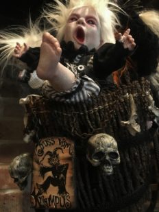 close-up detail of a custom basket with a hand-painted krampus sign and skull and screaming child doll