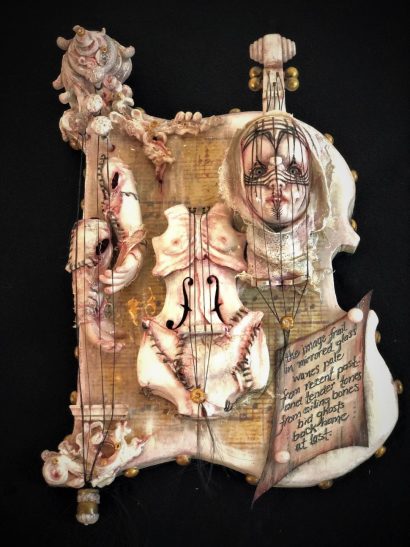 mixed media assemblage of a deconstructed art doll with a violin torso and severed head and hands mounted on board hand painted