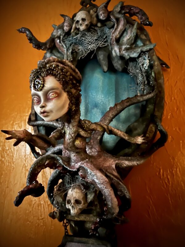 Wall-mounted Mixed Media art sculpture Lady Grace ocean goddess doll with tentacles in front of a stormy hand-painted sea