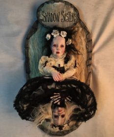 mixed media assemblage art doll goth repaint doll with black hair wearing white dress and white roses lift her skirt to reveal skeletal doll in black dress