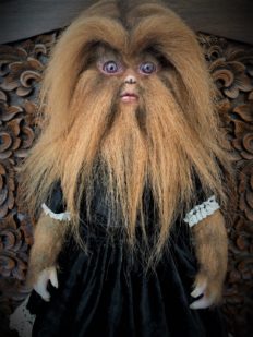 vintage-inspired werewolf artdoll with light brown fur covering her face and arms dressed in black velvet dress trimmed with white lace