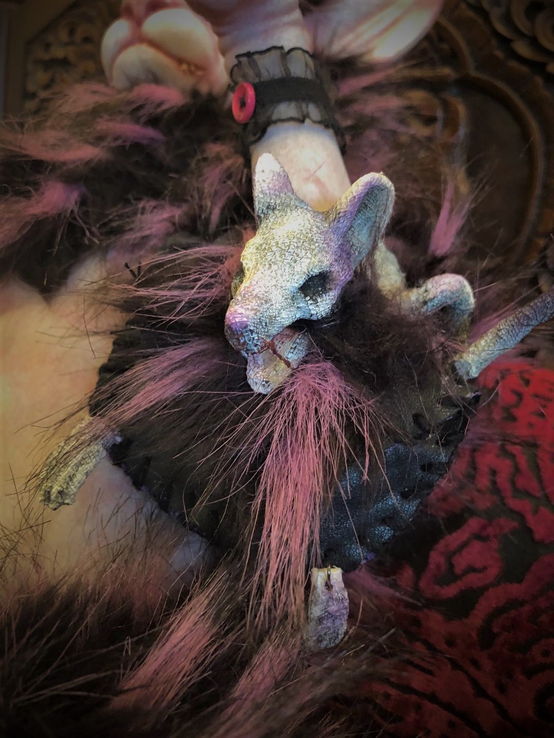 close up dead rat purse made of sculpted painted rat head leather and purple faux fur