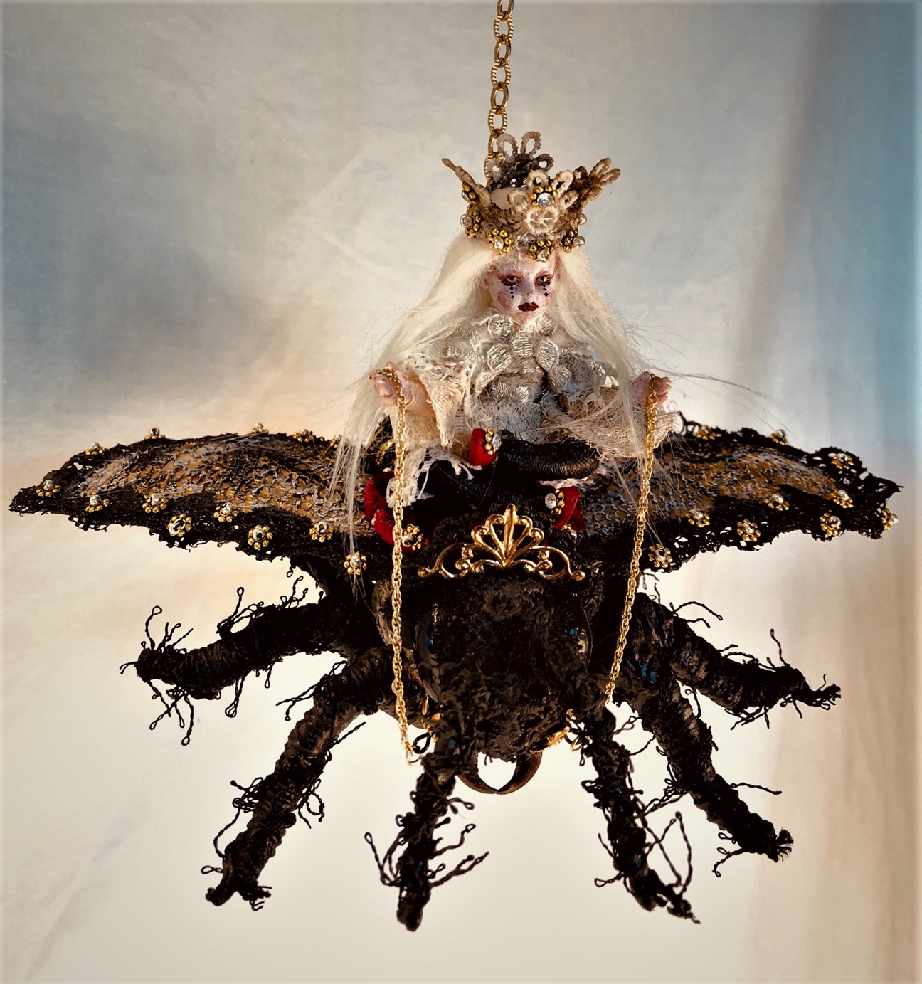 mixed media miniature gothic white queen rides a black lace-covered vintage crowned toy queen bee hung by goldtone chain