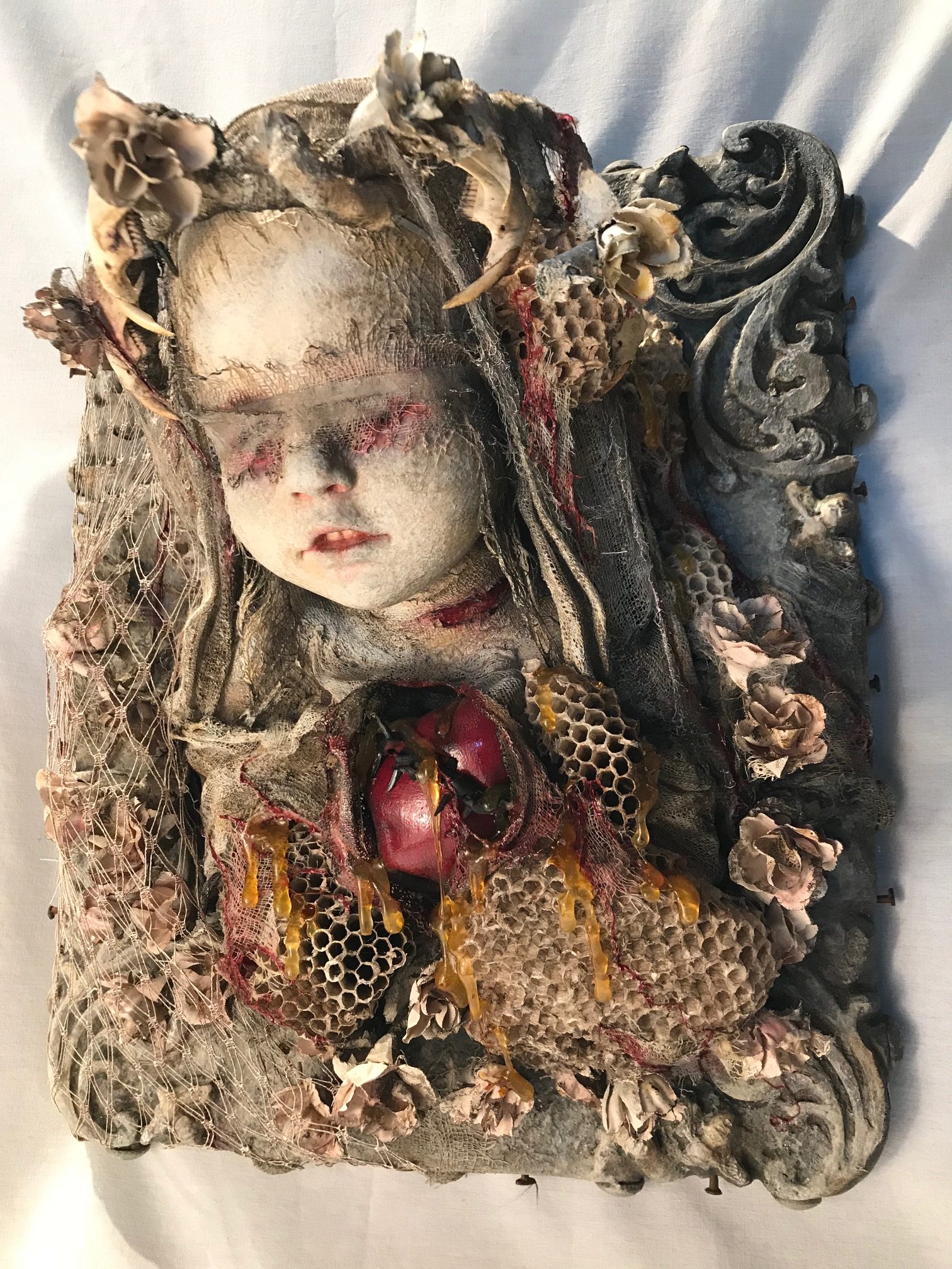 mixed media assemblage plaque blindfolded painted porcelain doll with bone and honeycomb