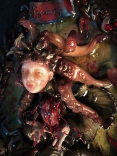 close-up of resin encased mixed media assemblage of a tiny tentacled, doll-faced creature floating in water holding a beating heart.