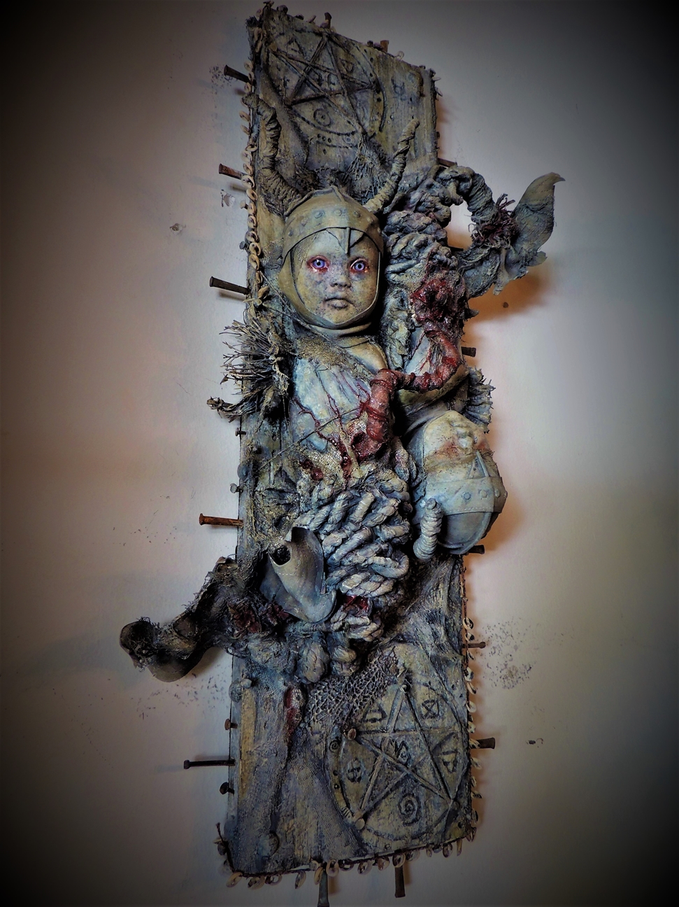 mixed media assemblage ghastly repainted baby dolls mounted on wooden board dark art pentagram