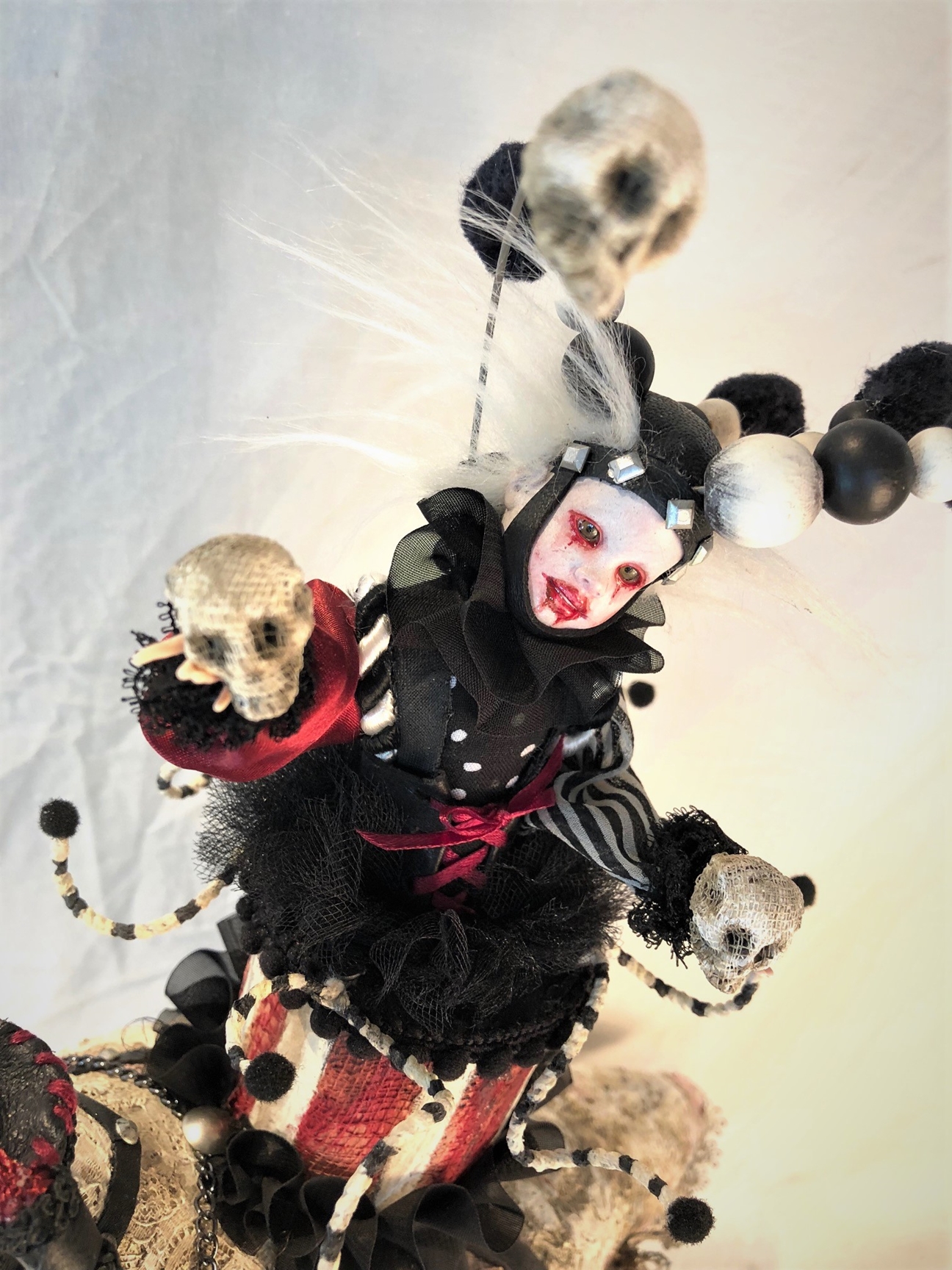 close-up mixed media miniature gothic costumed circus performer juggles skulls
