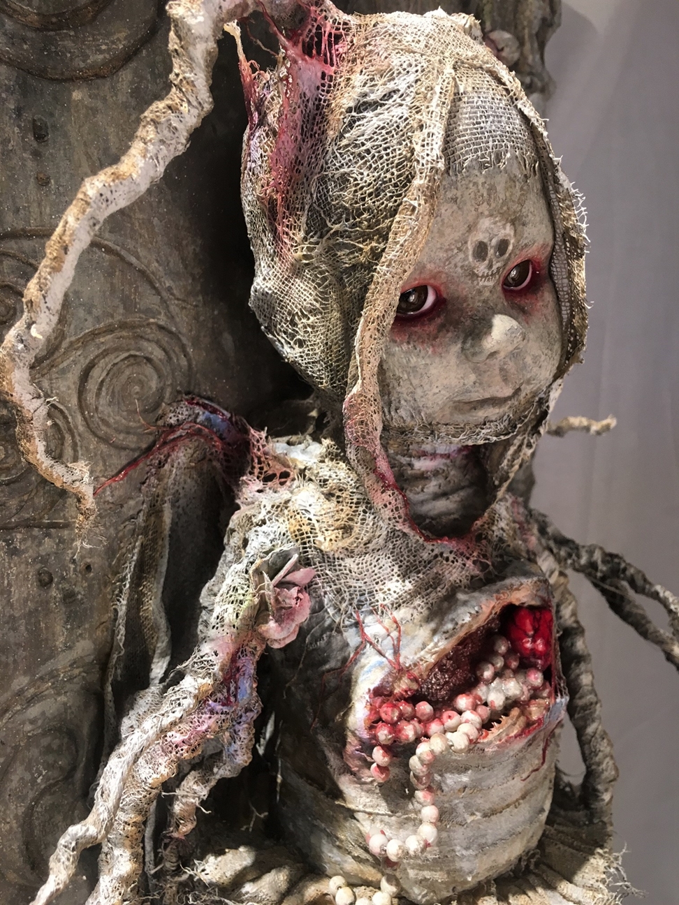 close up dark art mixed media assemblage sculpture of a macabre baby made with porcelain, bone & rope