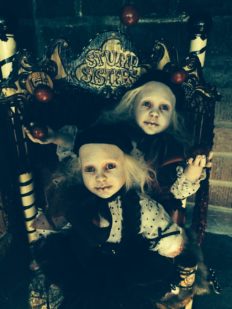 close-up of gothic sideshow circus sister act dolls sitting in a chair