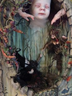 miniature shadowbox diorama with two tiny gothic dolls reaching for each other in a forest setting with a bigger doll above them