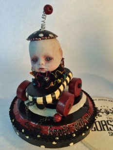 doll head gothic repaint circus-themed, red, black and white, babydoll with skull eyes on hand-painted wooden pullcart on wooden platform