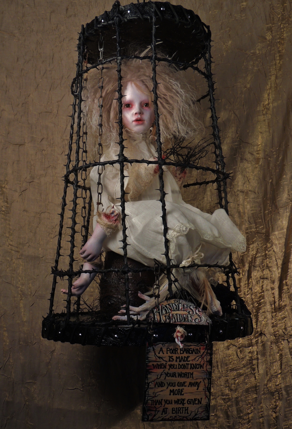 mixed media artdoll assemblage of a blonde caged damsel doll in a white gown with severed hands inspired by the Grimm fairytale