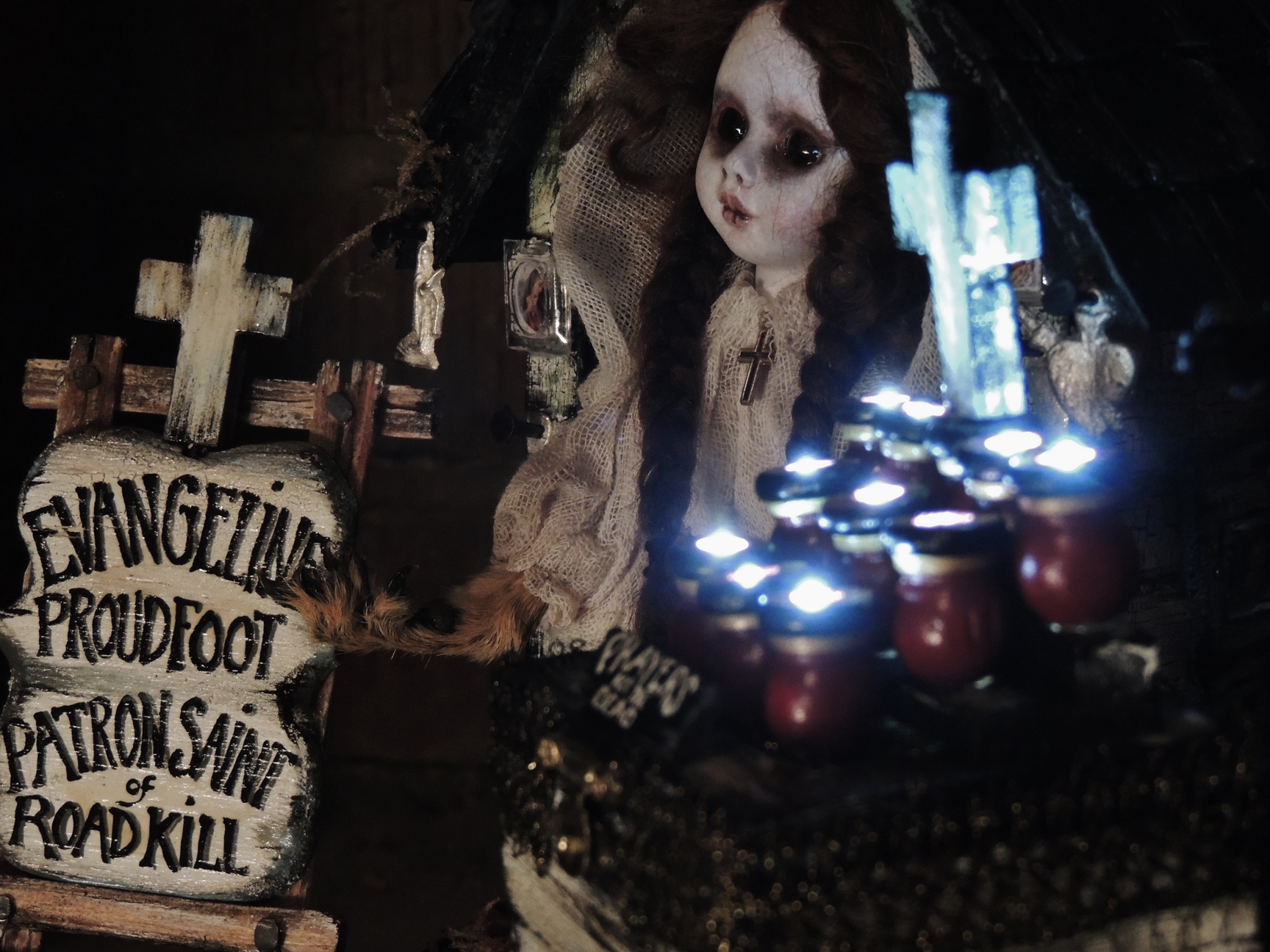 close-up of miniature mixed media taxidery assemblage of an altarpiece doll representing the Patron Saint of Roadkill