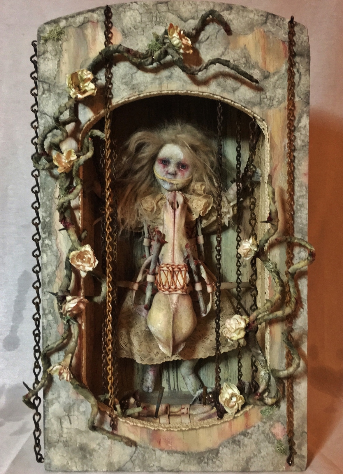mixed media assemblage shadow box earth tones with an imprisoned goth repainted doll.