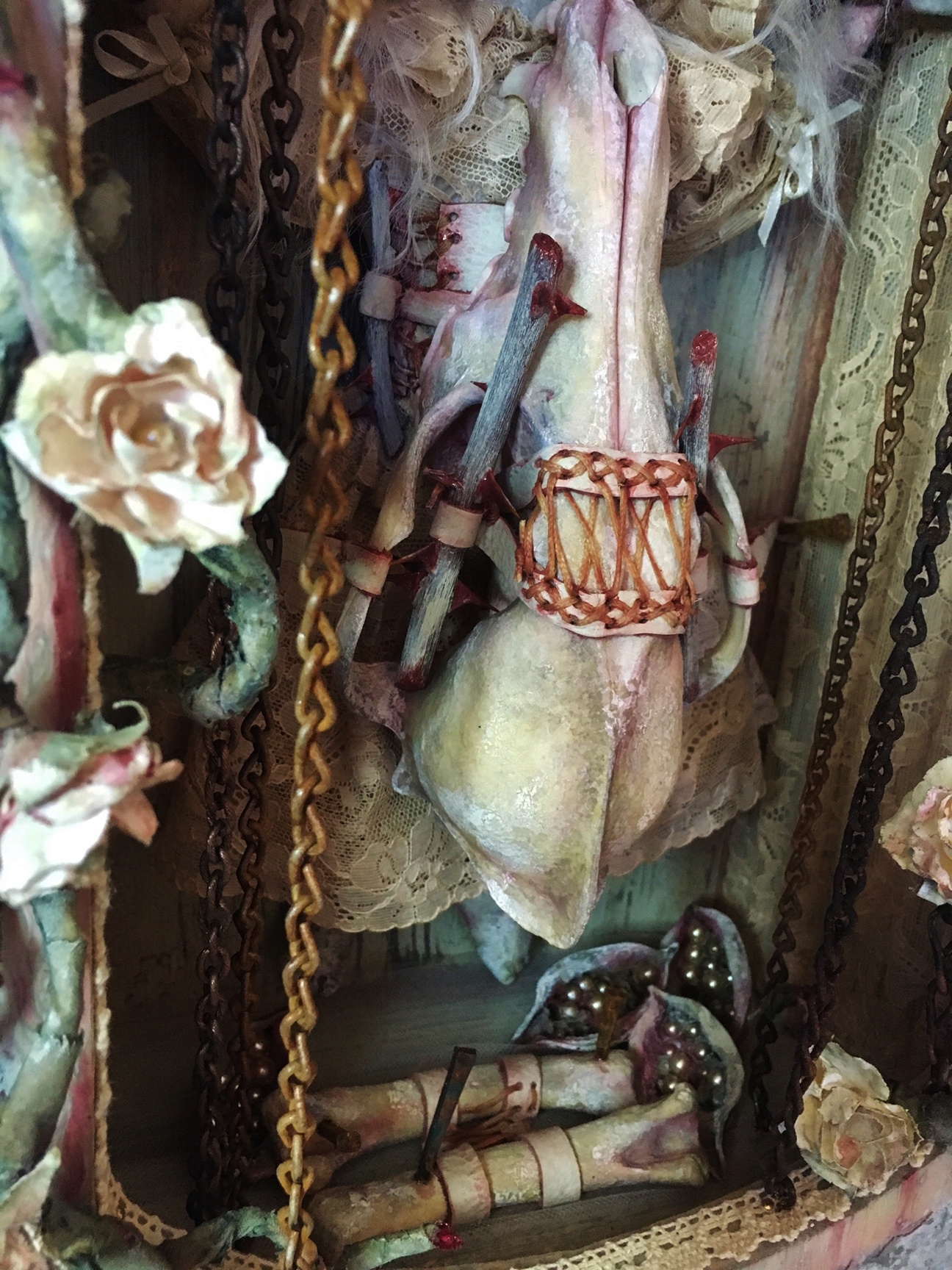 close-up of mixed media assemblage shadow box earth tones animal skull chains flowering vines