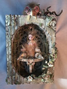 mixed media assemblage artpiece shadowbox gothic feathered songbird artdoll in a hand-painted shadowbox decorated with animal bones, chains and rose vines and a giant birdskull on top