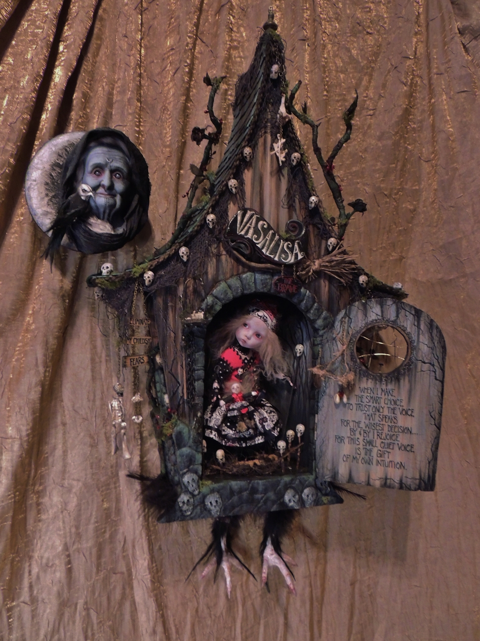 hand sculpted mini house with bird feet. Behind the door brave VasaLisa looks out for BabaYaga folk art mixed media assemblage