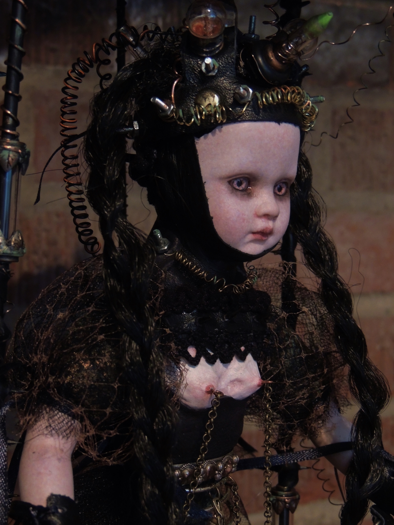 close-up gothic steampunk artdoll with black braides and machine hat