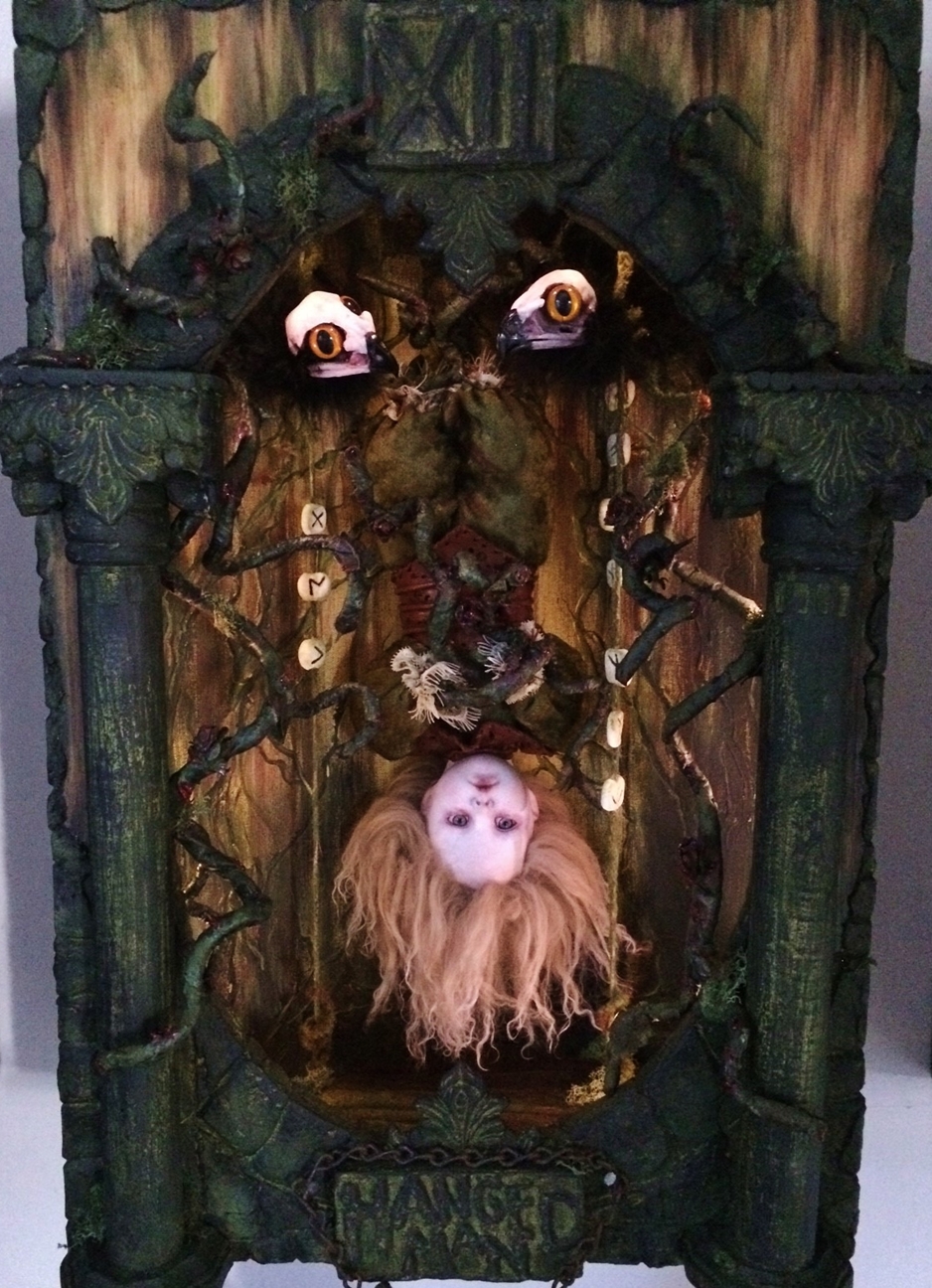 miniature shadowbox diorama with gothic artdoll hanging upside down in a forest setting two birds with skull heads above him